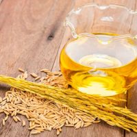 روغن سبوس برنج در کنار خوشه و دانه های برنج - روغن سبوس برنج